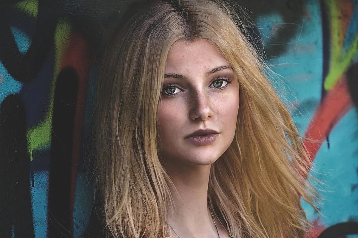Portrét ženy s dlouhými světlými blond vlasy.