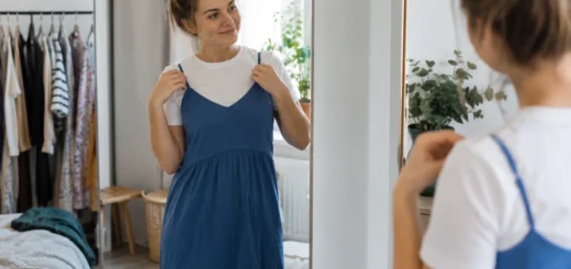 Žena u zrcadla zkouší modré šaty přes bílé tričko