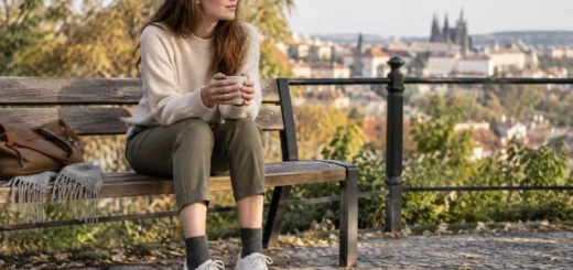 Žena sedí na lavičce v kotníkových kalhotách s jednobarevnými ponožkami